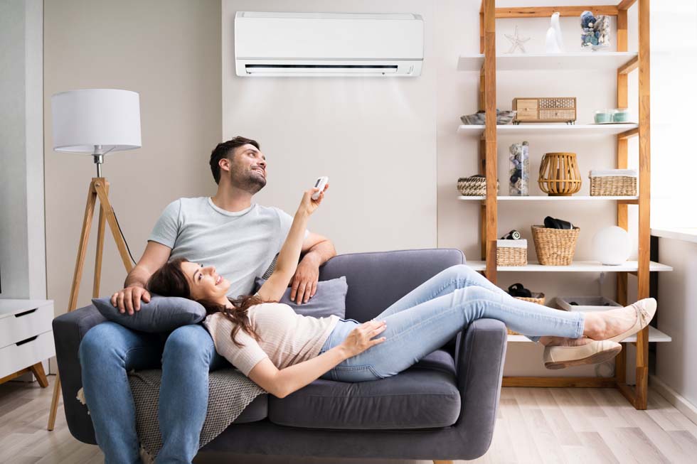 Femme heureuse tenant la télécommande du climatiseur