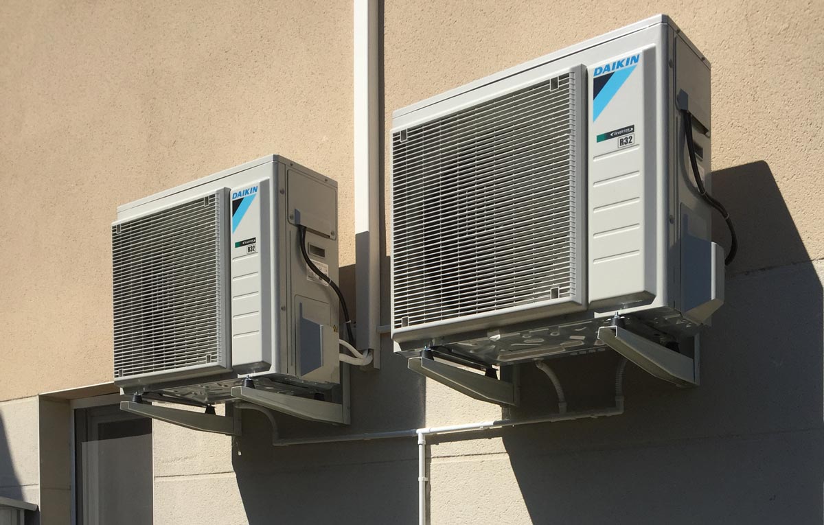 Deux blocs extérieur de pompe à chaleur Daikin suspendus sur un mur